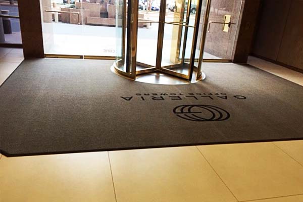 Monotonic curved floor mat with logotype for entrance group